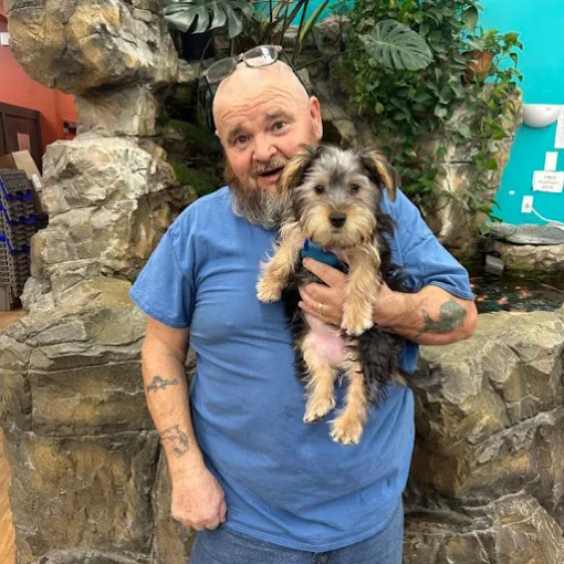 A man holding a small puppy
